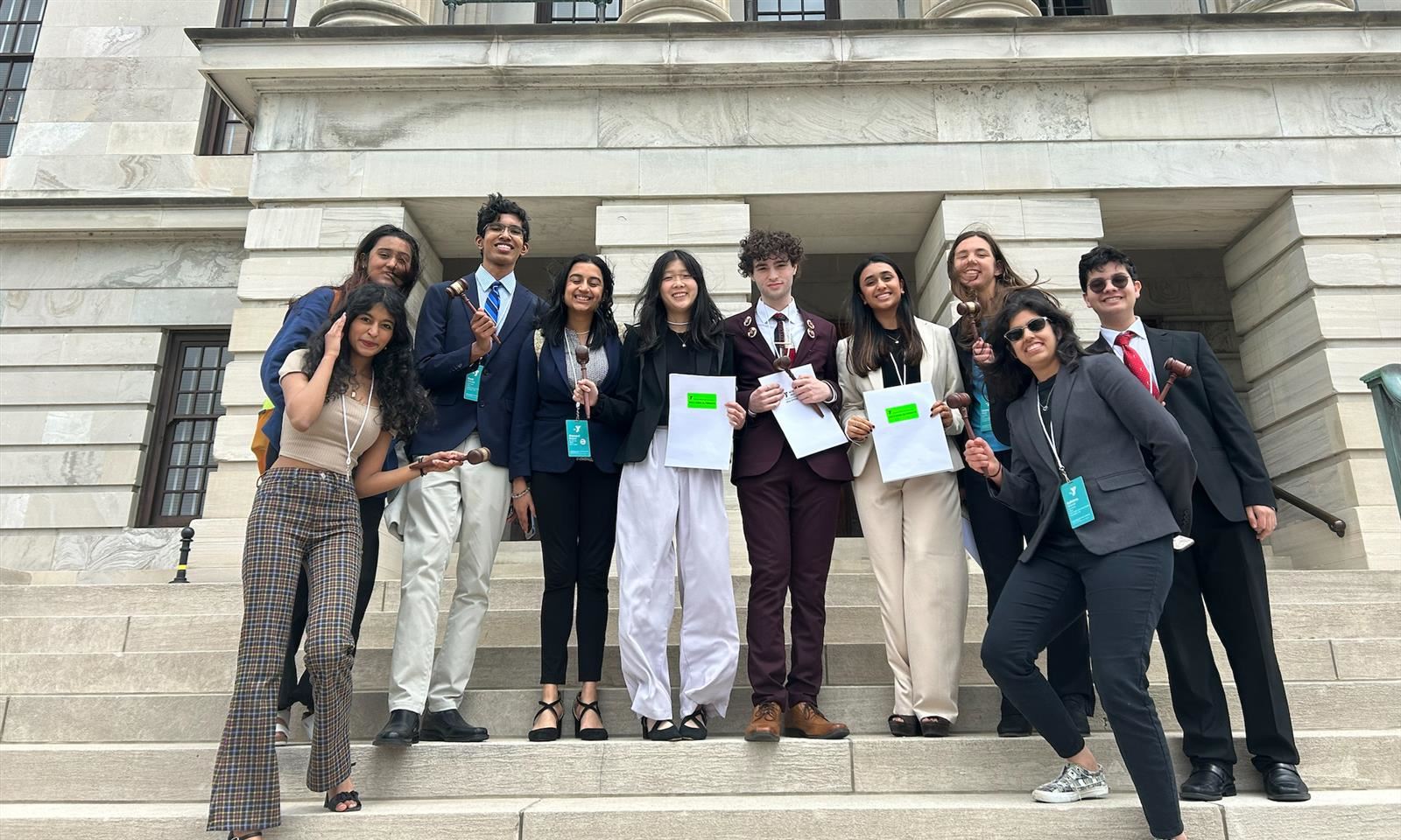 Students take a picture on the steps of a building